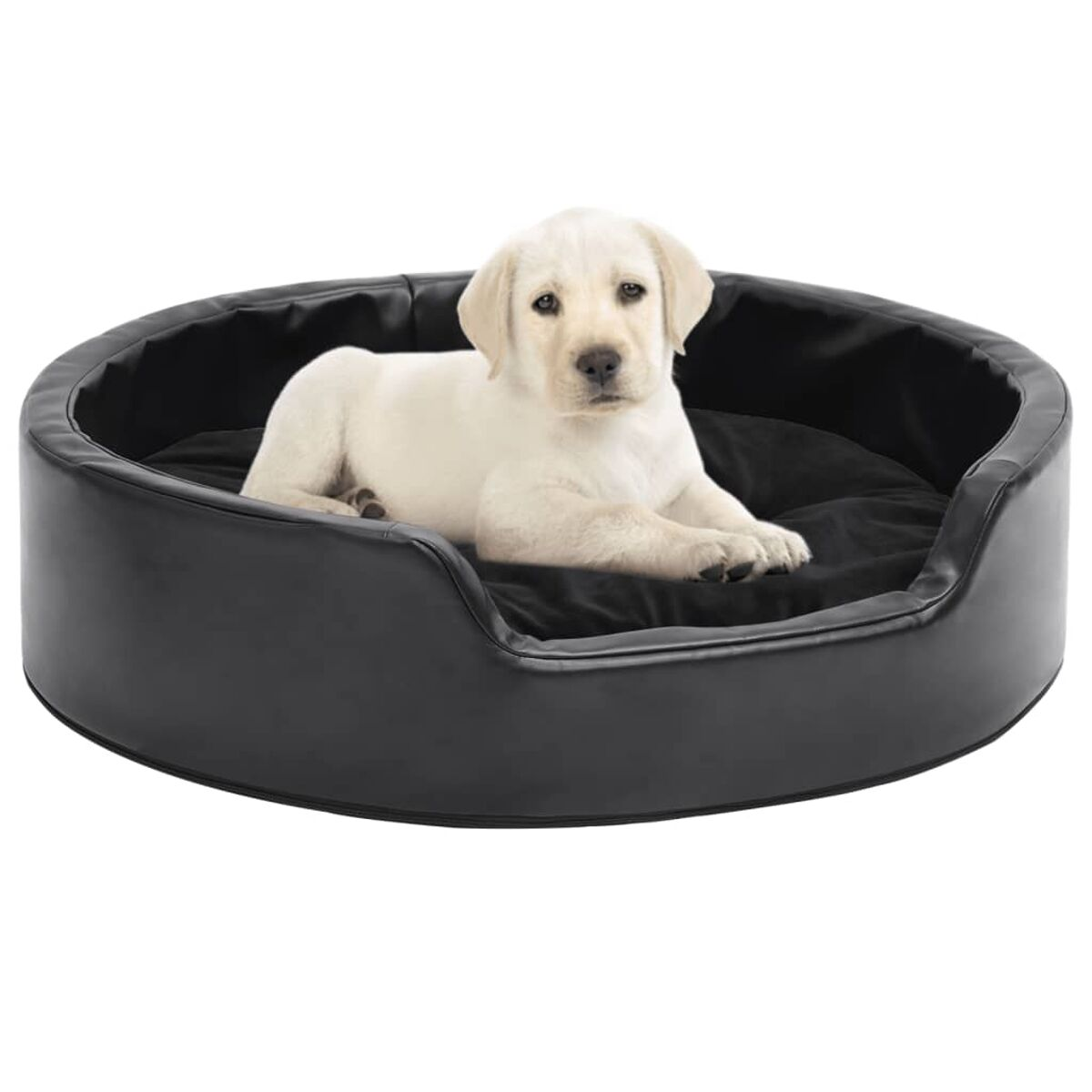 Weißer Welpe liegt in einem schwarzen Hundebett. Das Bett ist rund und hat einen niedrigen Rand.