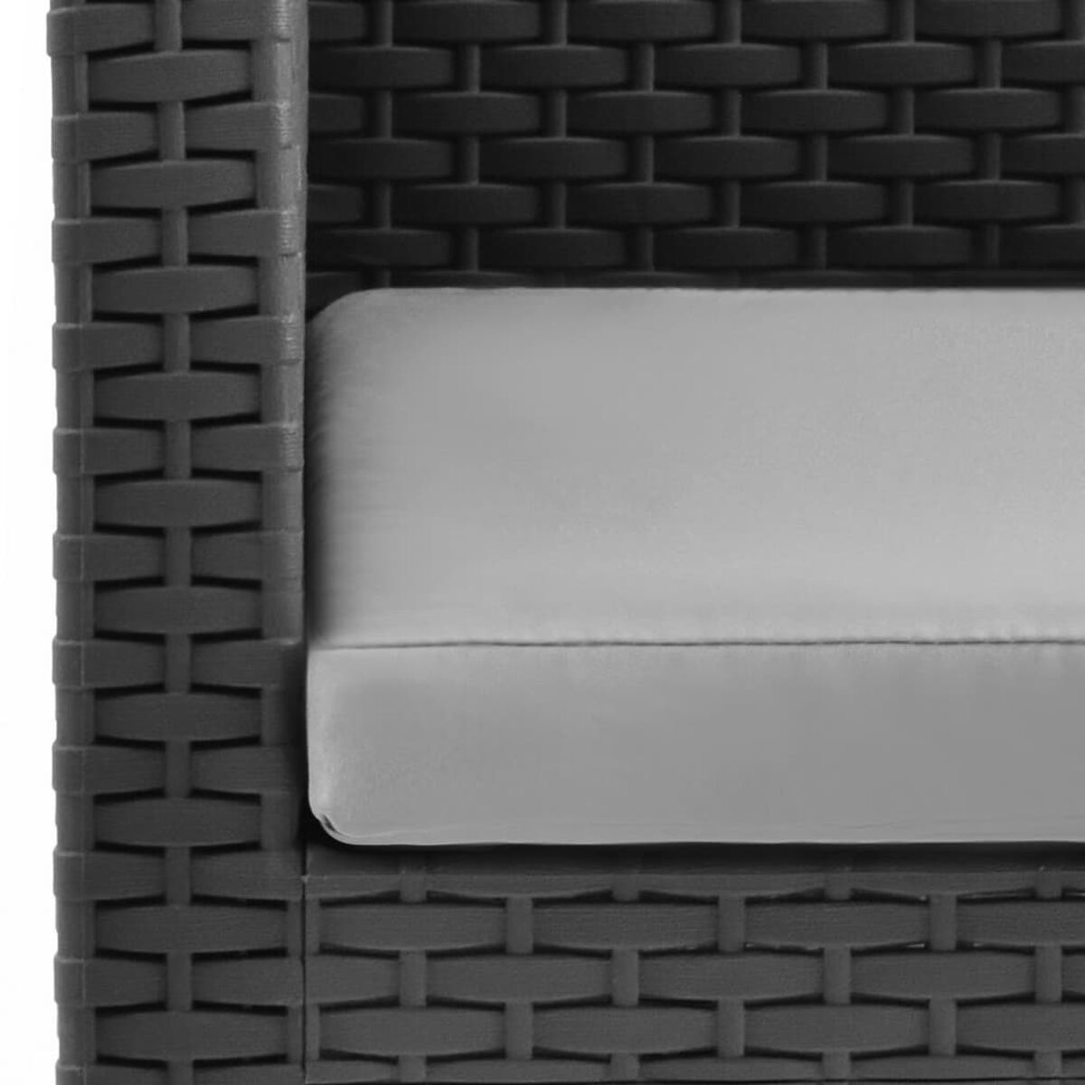 Detail eines dunklen Korbmöbel-Sofas mit grauem Kissen. Nahaufnahme, Textur sichtbar.