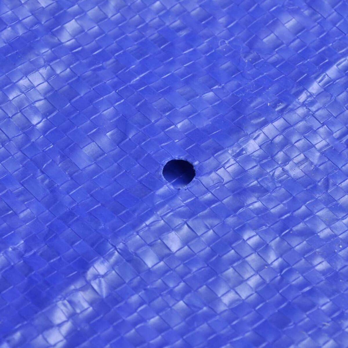 Blaue Plane mit einem Loch. Gewebte Textur. Nahaufnahme.