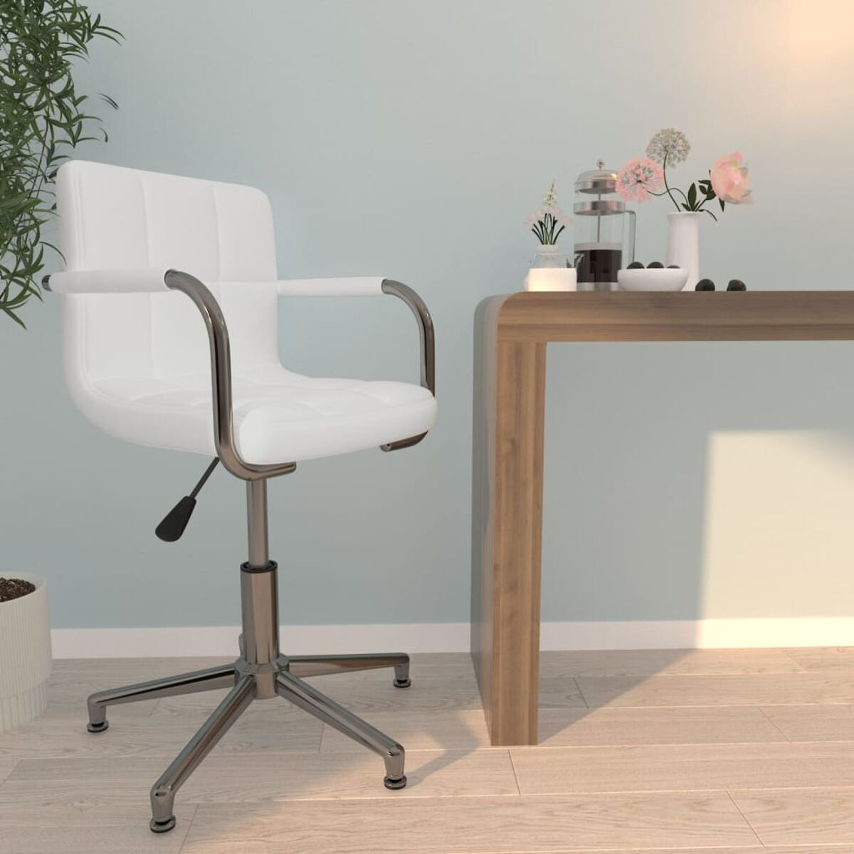 Weißer Bürostuhl, Holztisch mit Blumen und Deko. Hellblaue Wand und Holzboden.