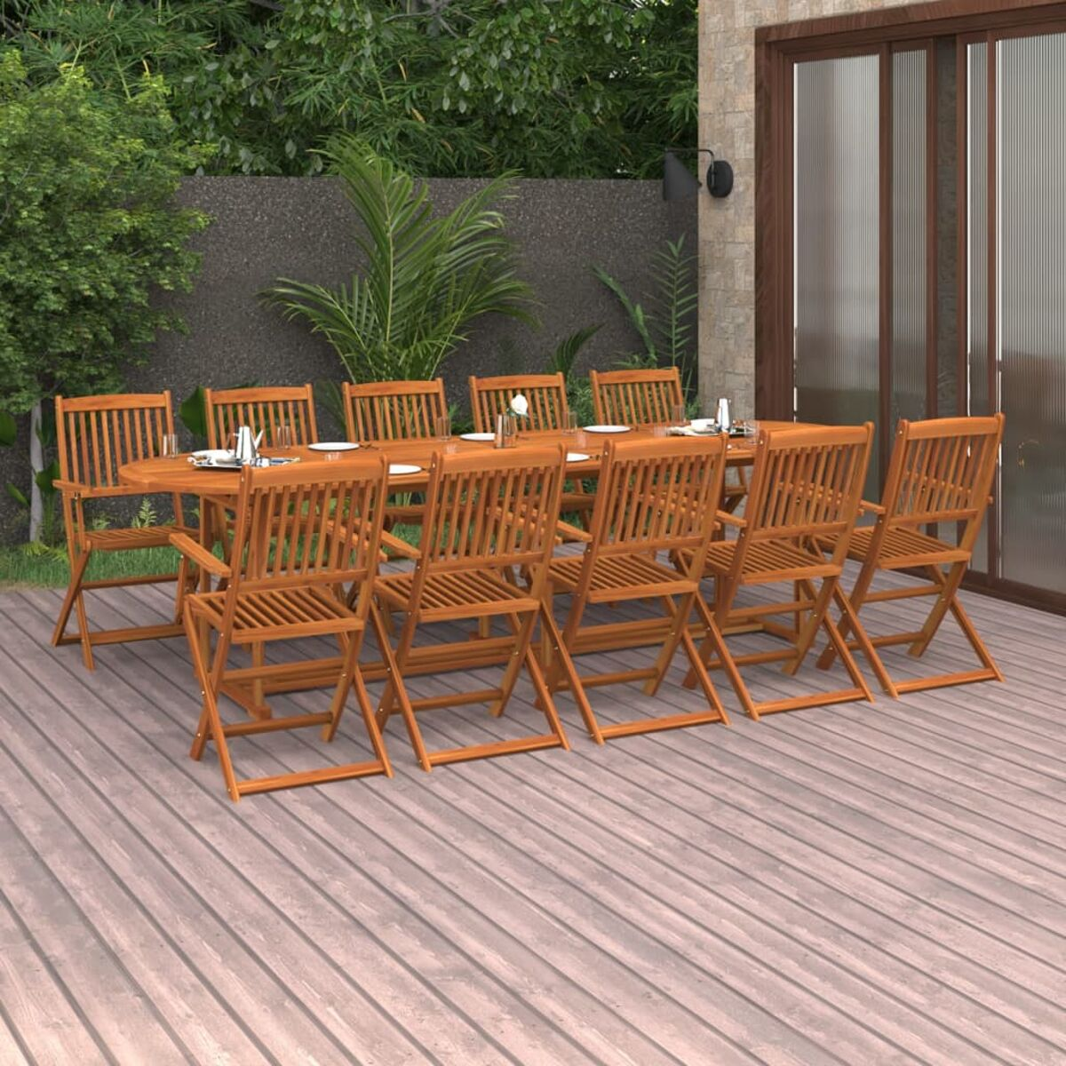 Ein Holztisch mit zehn Stühlen auf einem Holzdeck, bereit für eine Mahlzeit, mit Garten im Hintergrund.