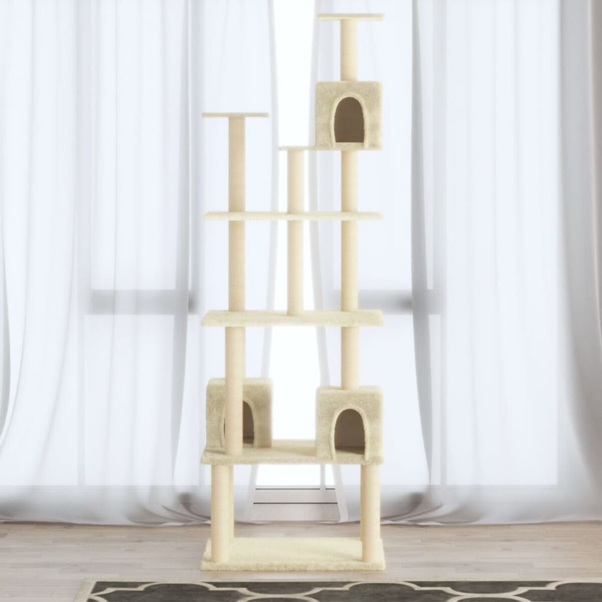 Beiger Katzenbaum mit mehreren Plattformen und Verstecken, in einem Raum mit Vorhängen.