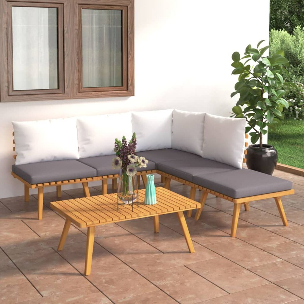 Terrassenset im Freien mit Holzrahmen, grauen Kissen, weißen Kissen und einem kleinen Couchtisch.