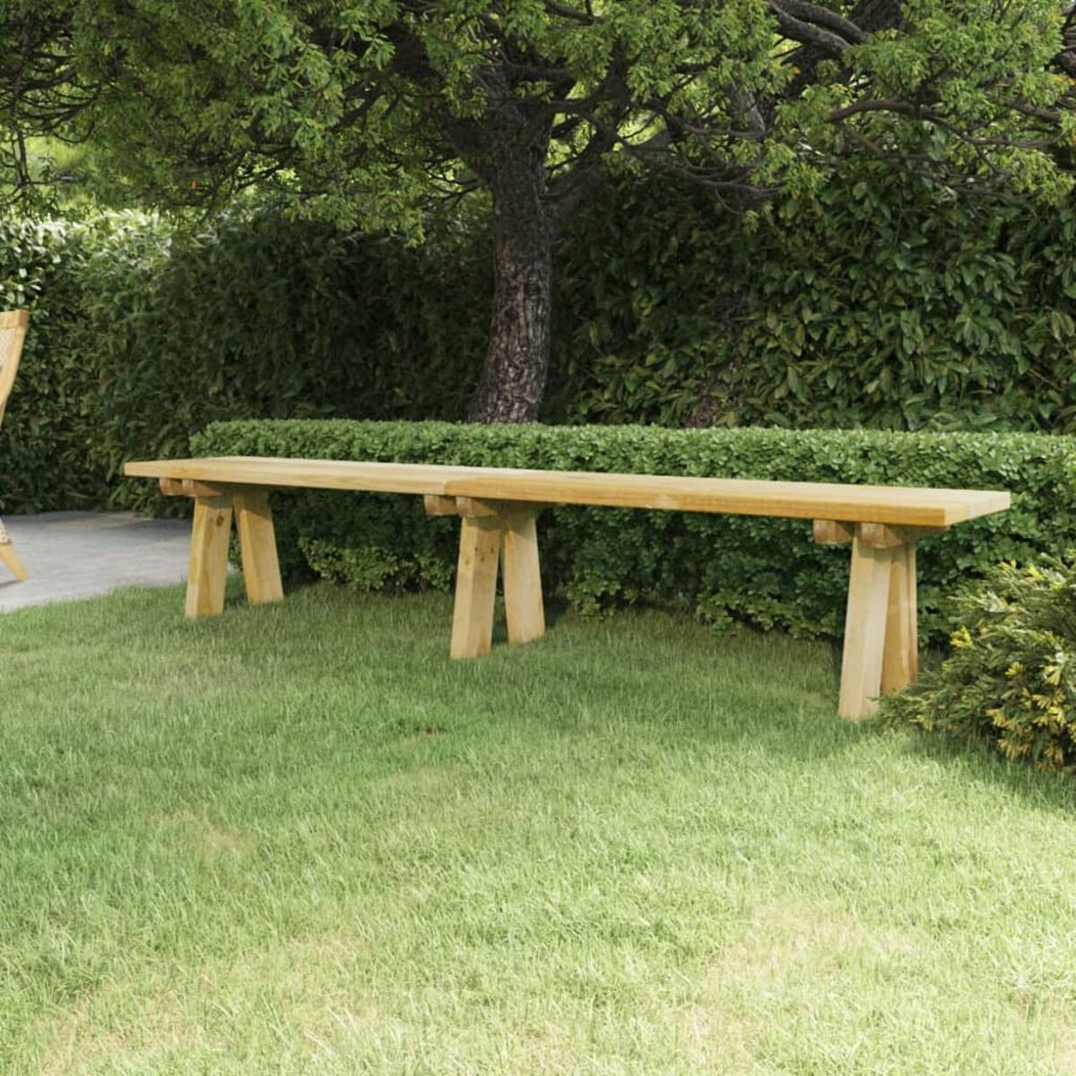 Zwei Holzbänke auf grünem Gras unter einem Baum und einer Hecke, im Freien.