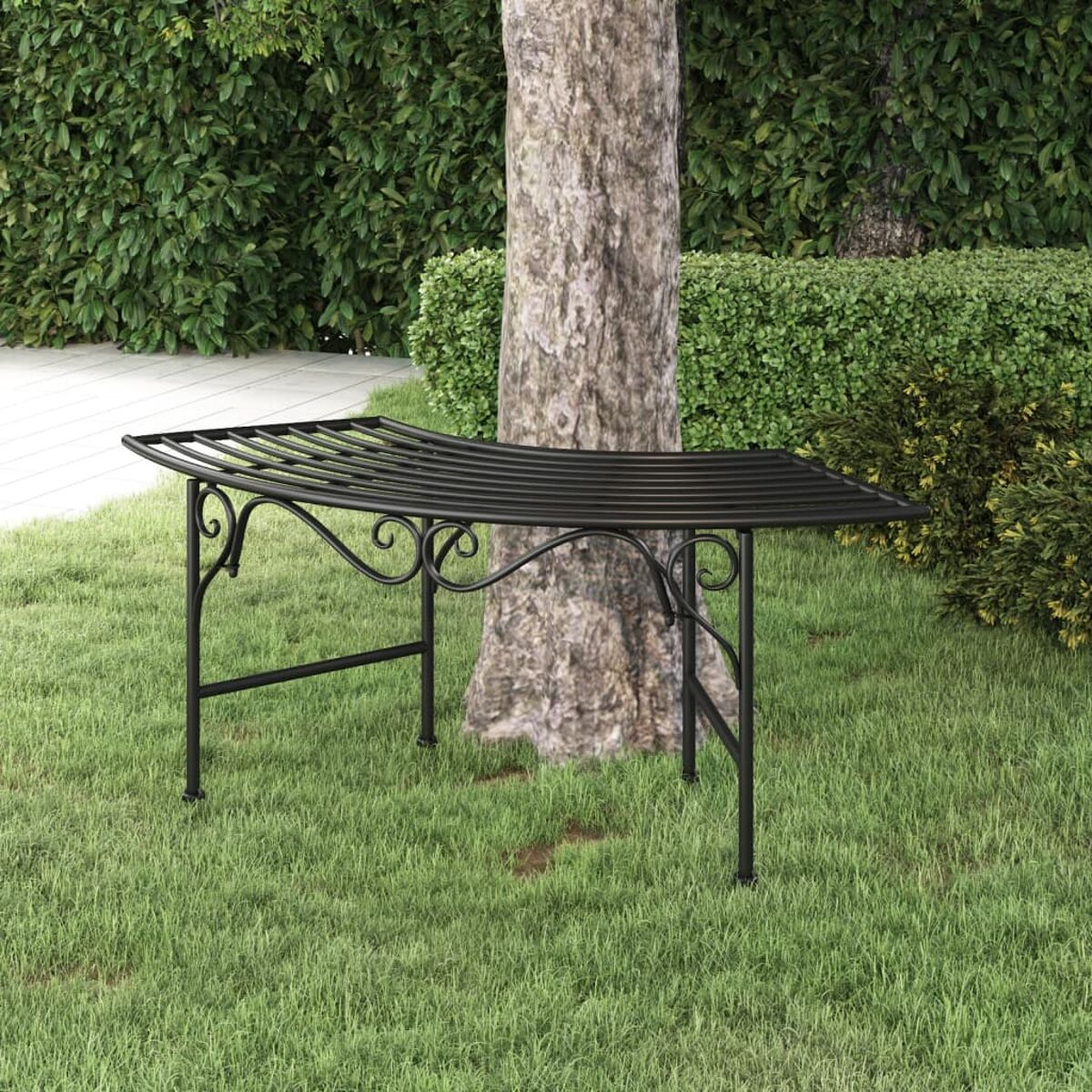 Panca in metallo nero sotto un albero in un ambiente di erba verde.