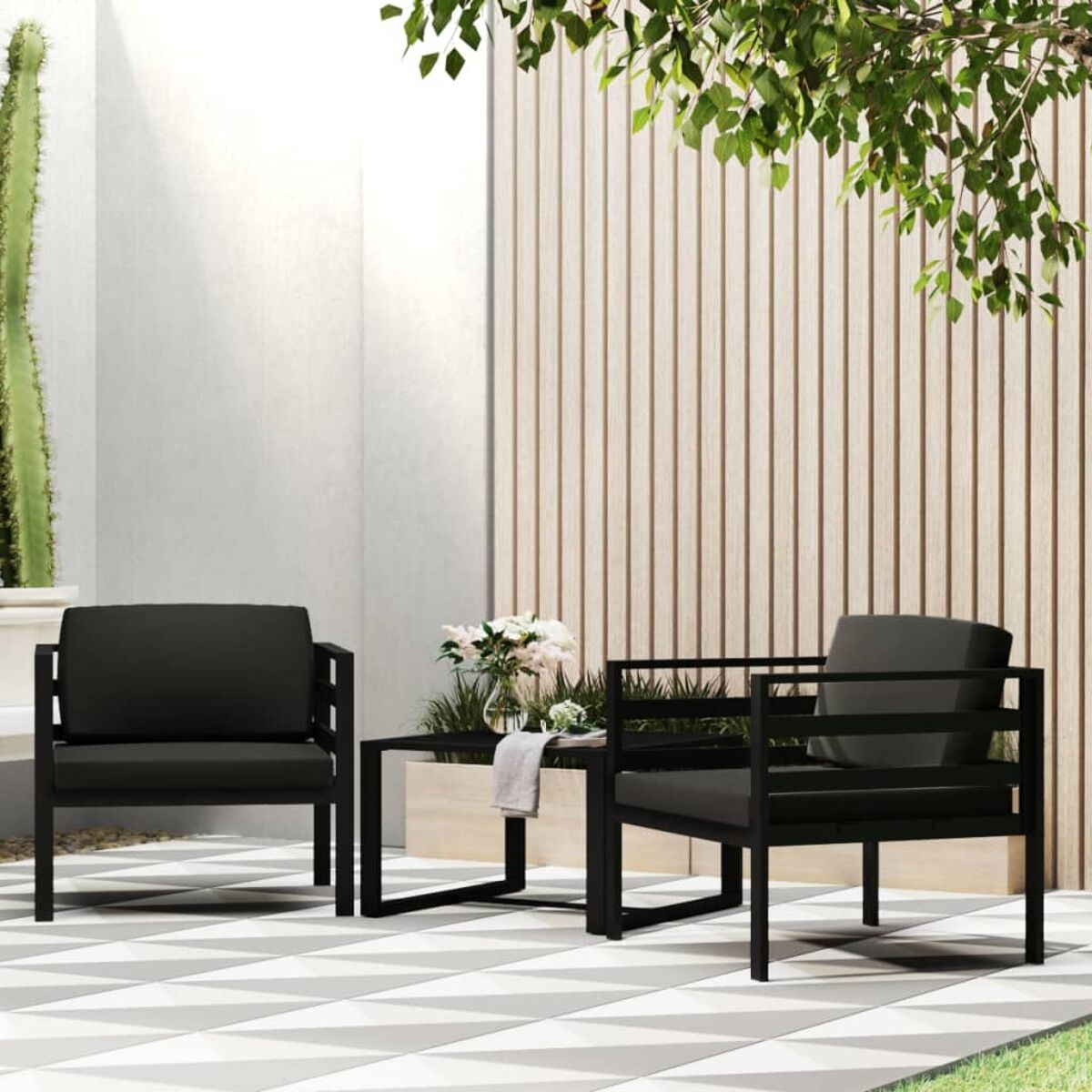 Outdoor-Sitzgruppe: zwei schwarze Sessel und ein Couchtisch auf einer gemusterten Terrasse.
