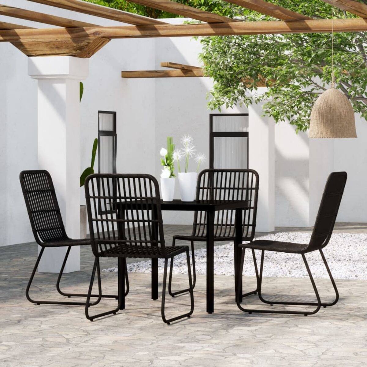 Outdoor-Essgruppe mit schwarzem Tisch und Stühlen. Der Hintergrund ist eine Terrasse mit Pflanzen.