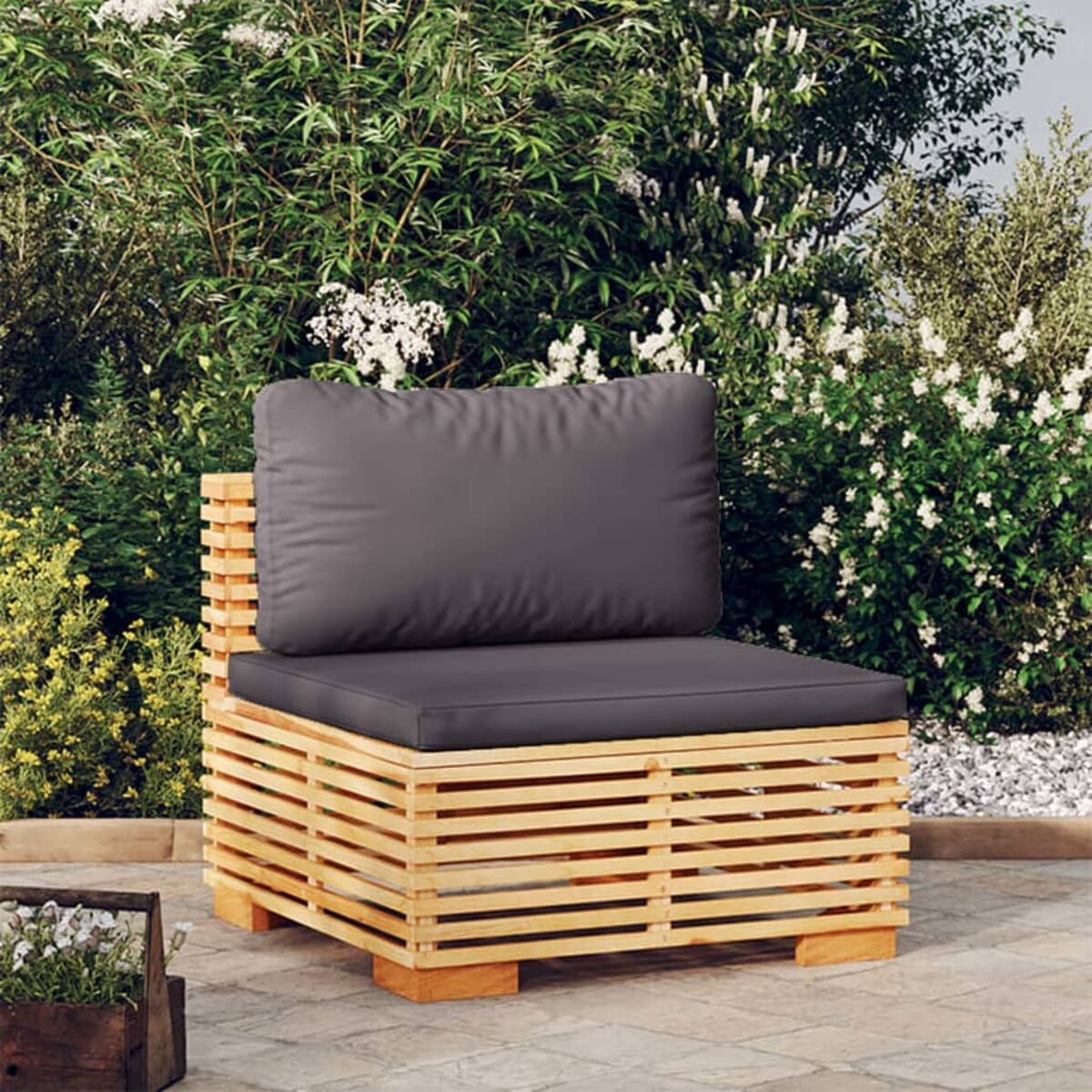 Ein hölzerner Stuhl im Freien mit grauem Kissen auf einer Terrasse, im Hintergrund Pflanzen.