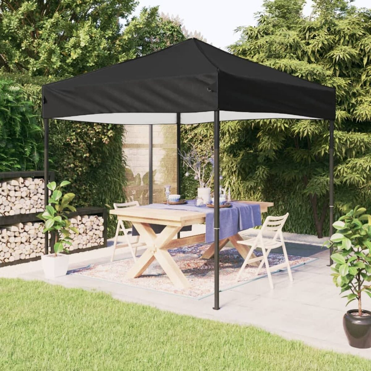 Schwarzer Outdoor-Pavillon mit Tisch zum Essen. Grünes Gras, Pflanzen und Garten.