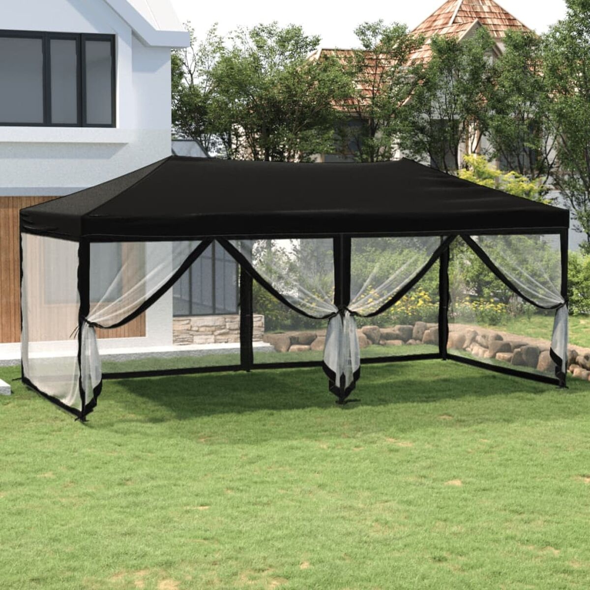 Schwarzes Outdoor-Zelt mit weißen Vorhängen auf grünem Gras und einem weißen Haus.