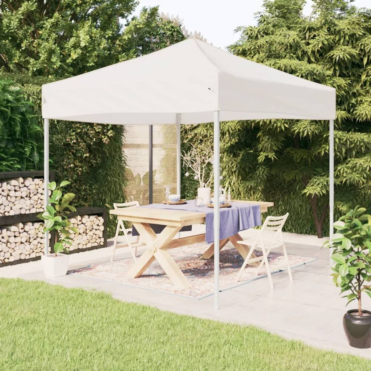 Weißer Pavillon mit Tisch und Stühlen darunter, in einem Garten.