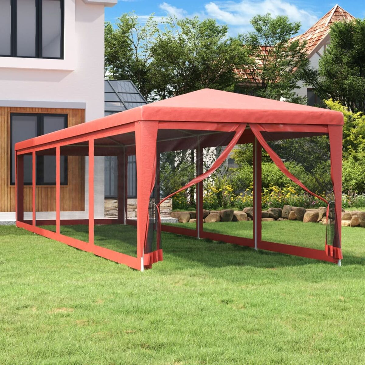 Ein roter Pavillon steht auf grünem Gras. Ein Haus und Bäume sind im Hintergrund.