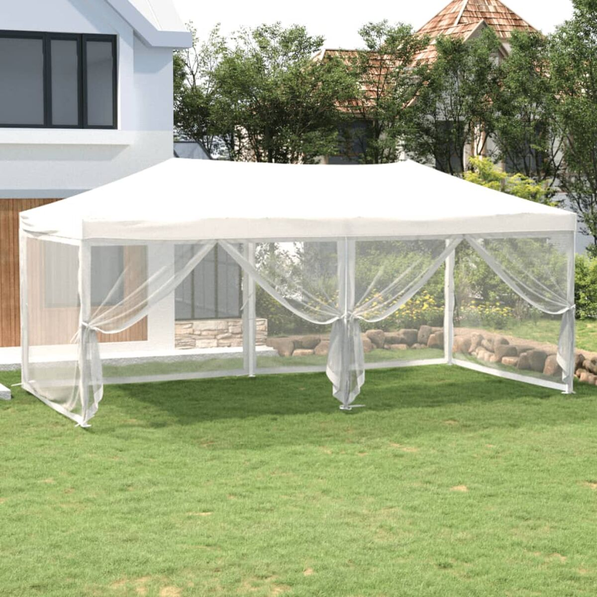 Weißes Outdoor-Pavillon-Zelt mit Moskitonetz, auf grünem Gras in der Nähe eines Hauses.