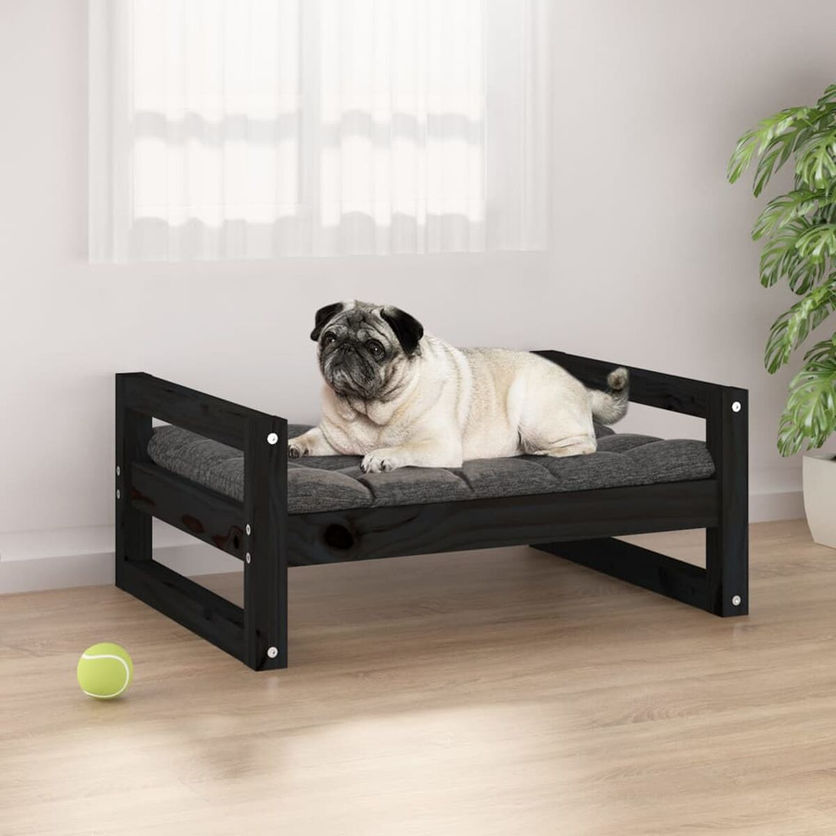 Mops auf einem schwarzen Holzbett.