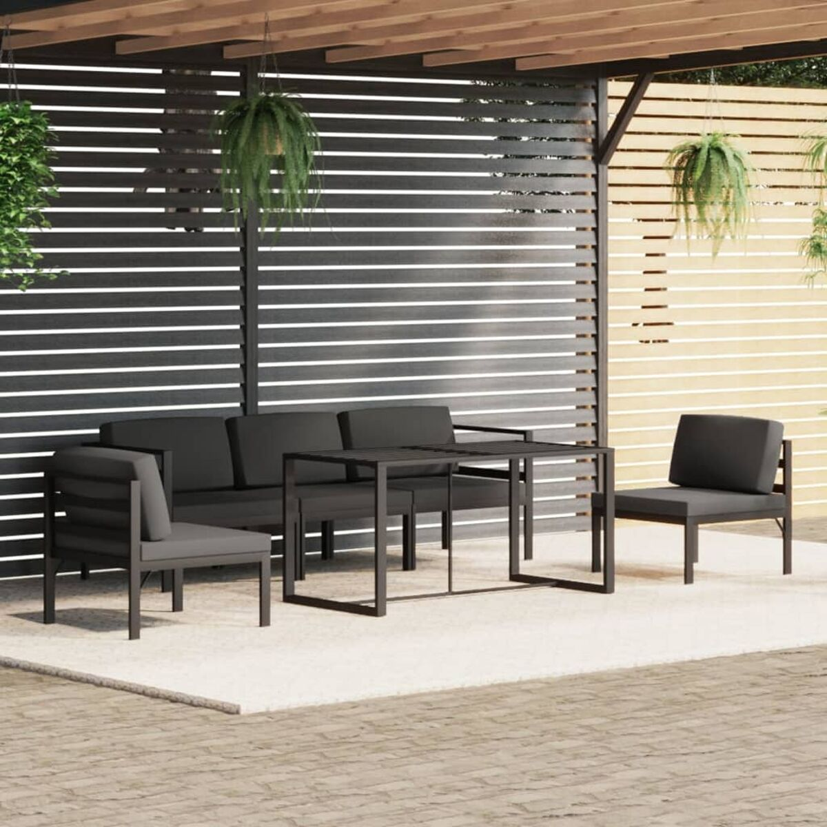 Outdoor-Sitzgruppe unter einer Pergola. Besteht aus Sofa, Stühlen und Tisch.