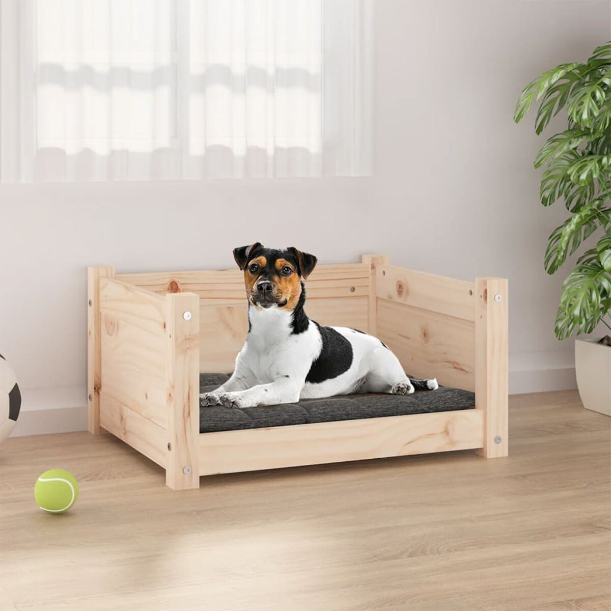 Ein Hund in einem Holzbett mit dunkelgrauem Kissen.