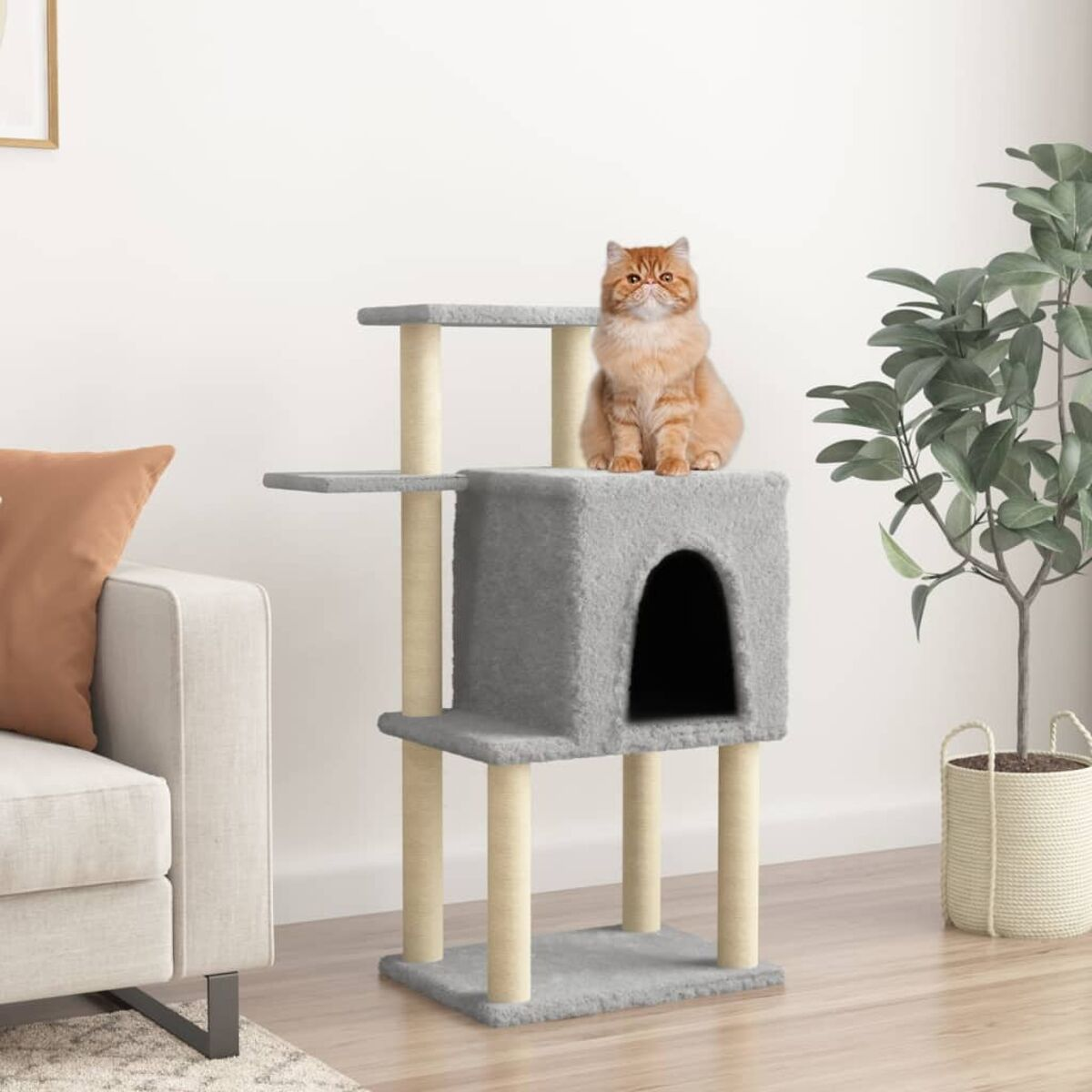 Eine Katze sitzt auf einem grauen Katzenbaum mit geschlossenen Bereichen, in einer häuslichen Umgebung.