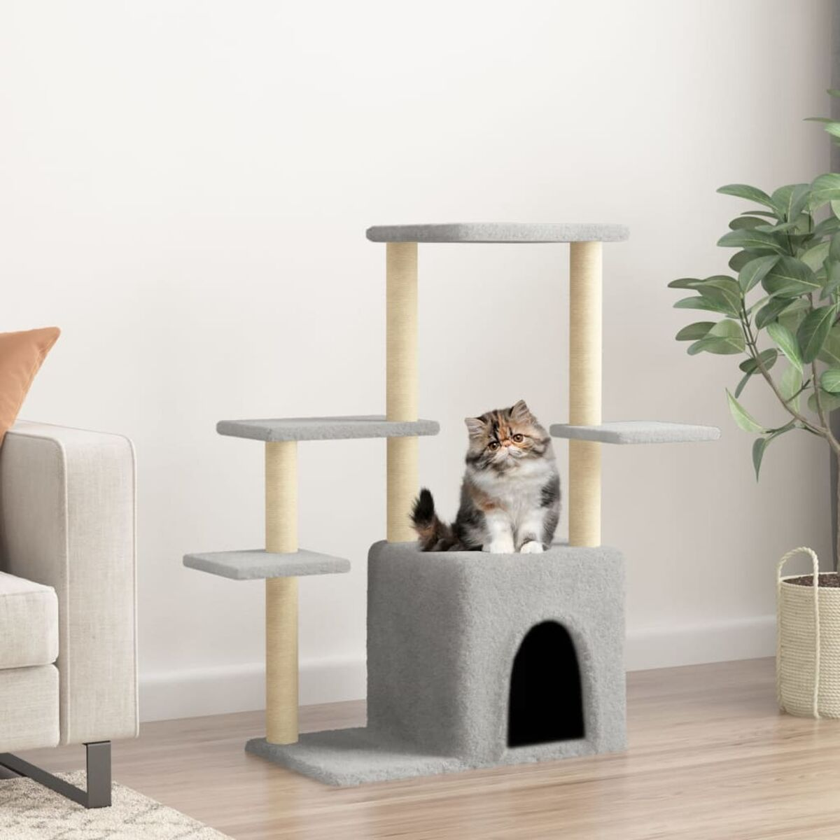 Katze sitzt auf einem grauen Katzenbaum, mit Haus und Plattformen, in einer Heimumgebung.
