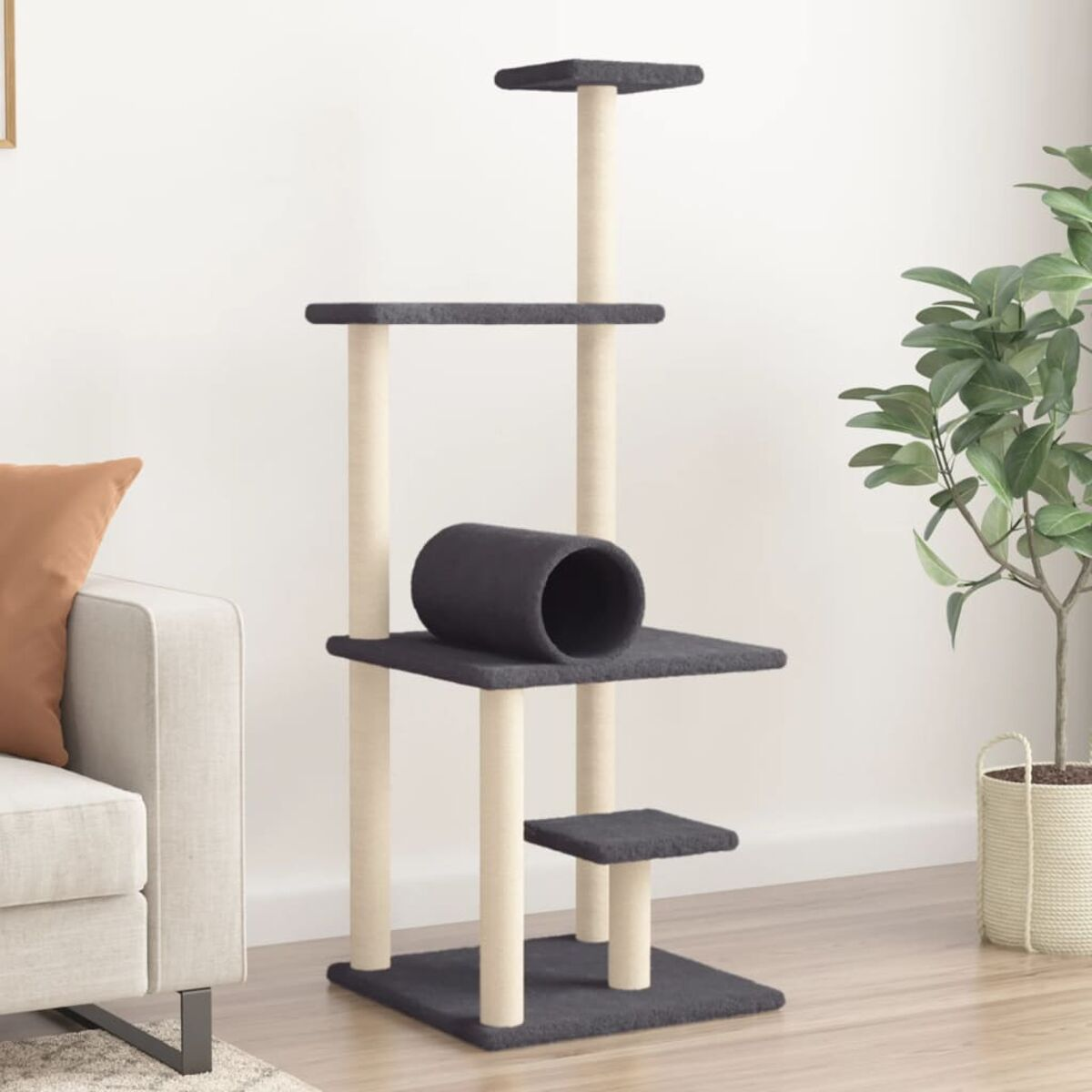 Ein Katzenbaum in einem Wohnzimmer. Der Baum ist beige und grau. Im Hintergrund sind ein Sofa und eine Pflanze.