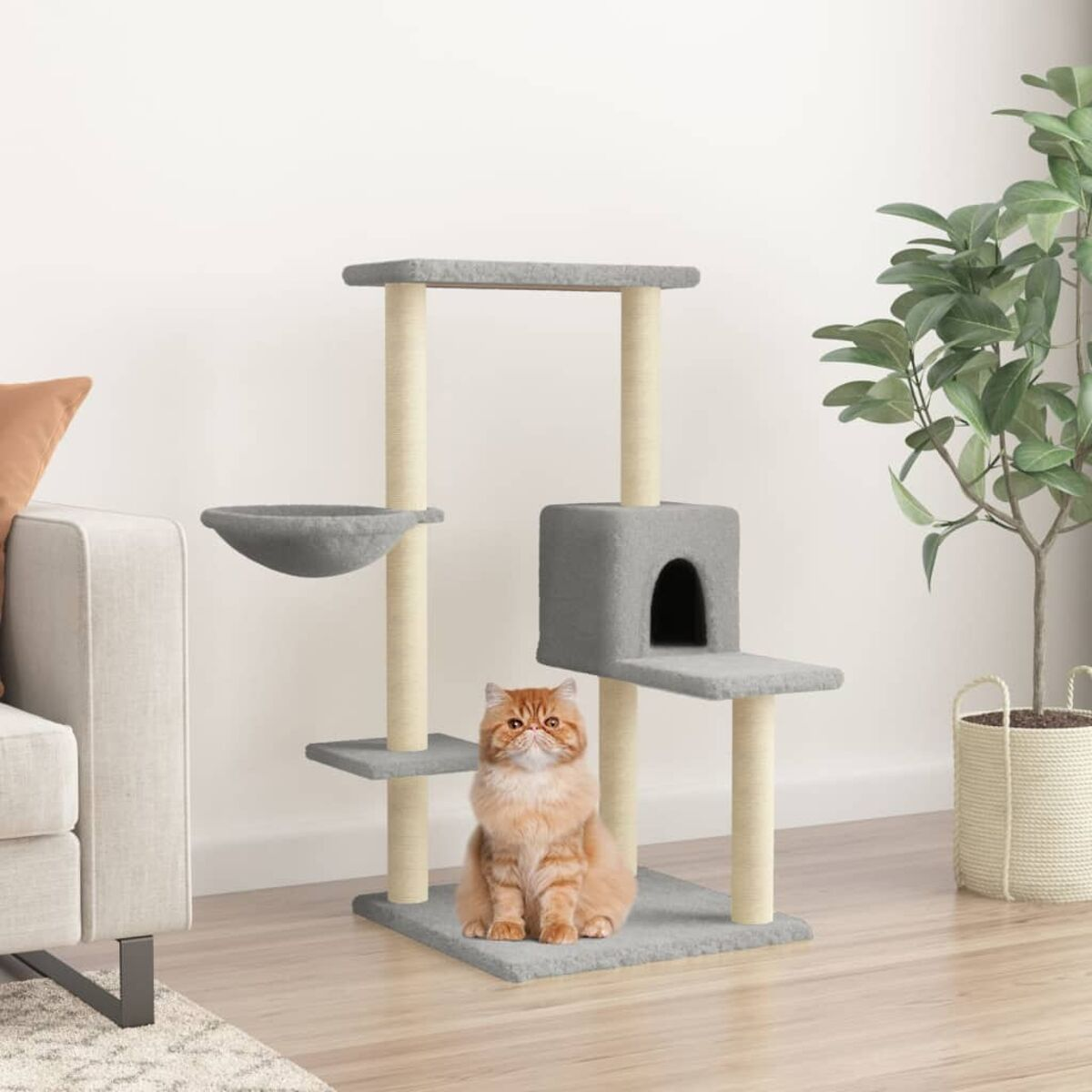 Katzenbaum mit Katze darauf. Der Baum hat mehrere Plattformen, eine Höhle und eine Hängematte.