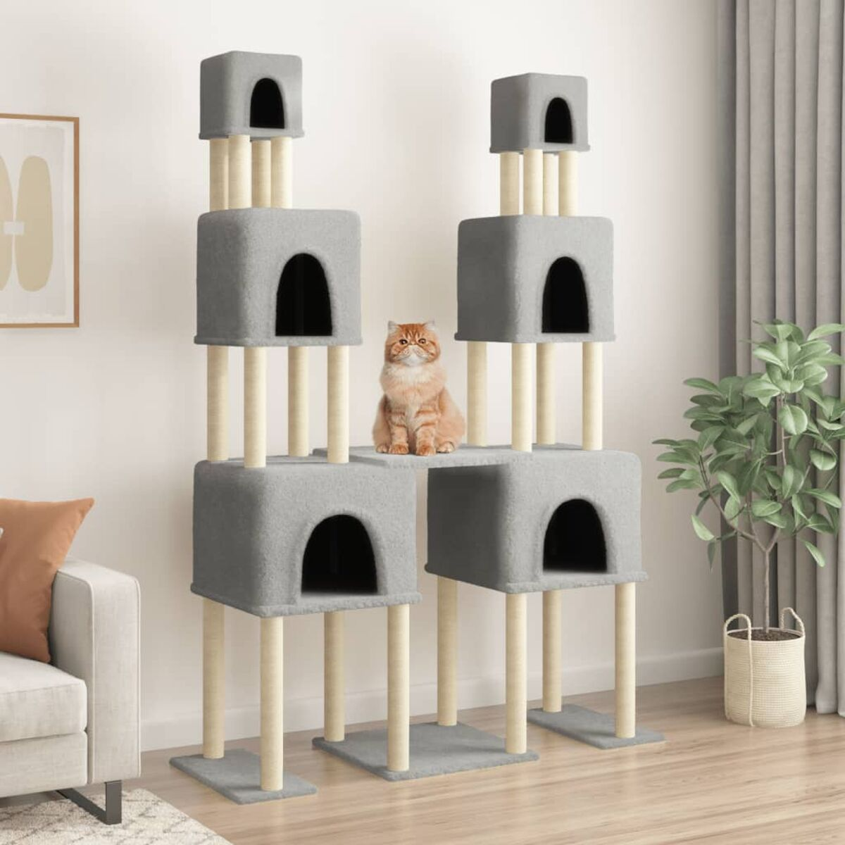 Katzenbaum mit grauen Höhlen und beigen Stützen. Eine rote Katze sitzt in der Mitte.