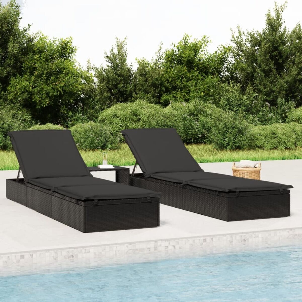 Zwei schwarze Outdoor-Liegen mit Kissen und einem Beistelltisch, in der Nähe eines Pools.