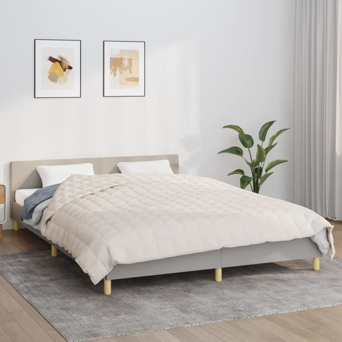 Schlafzimmer mit Bett, weißer Decke, zwei Bildern und Pflanze.