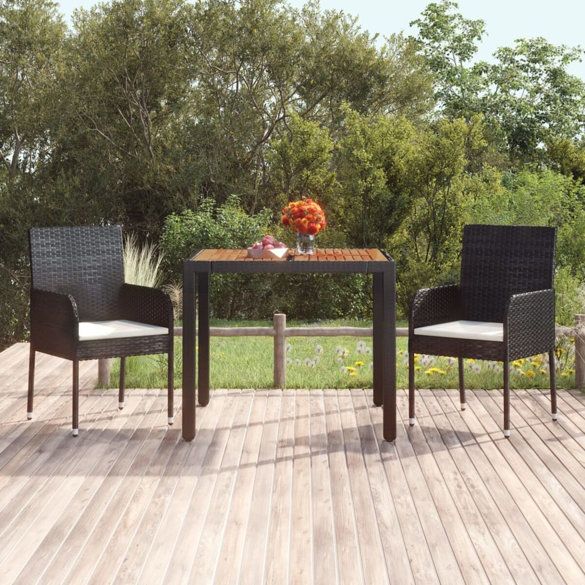Gartenmöbel-Set: zwei schwarze Stühle, ein Tisch mit Blumen. Holzdeck, grüner Hintergrund.