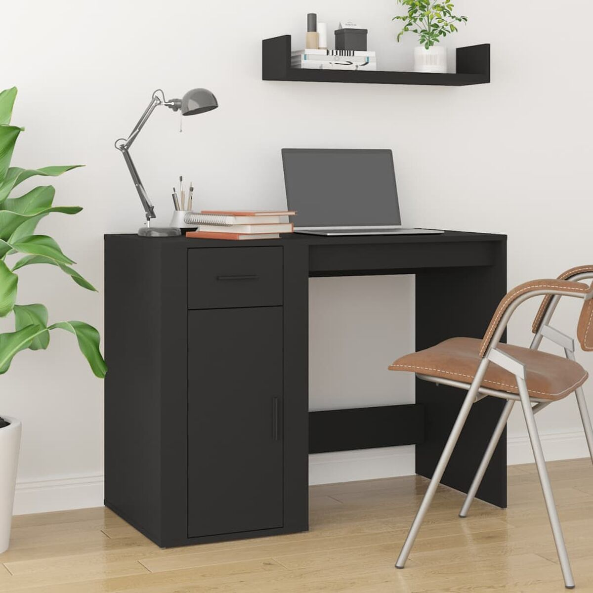 Schwarzer Schreibtisch mit Schubladen und einer Tür. Laptop und Lampe oben drauf.