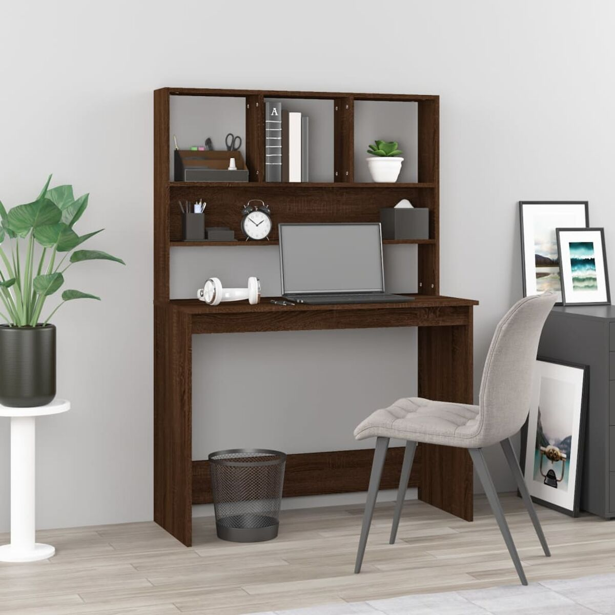 Holzschreibtisch mit Aufsatz, Laptop und Bürobedarf vor hellgrauer Wand.