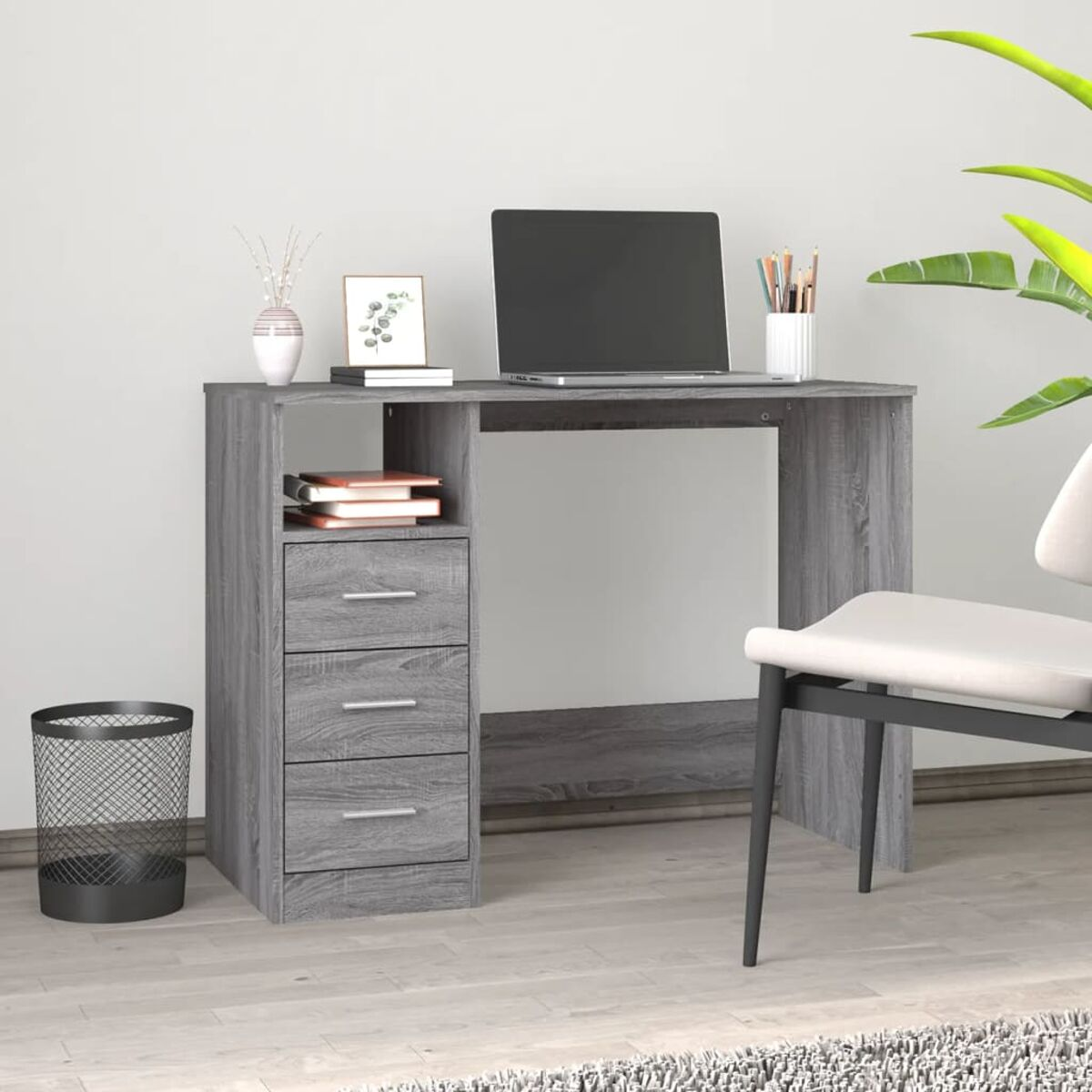 Grauer Holzschreibtisch mit Schubladen, Laptop, Zubehör, Pflanze und Stuhl.