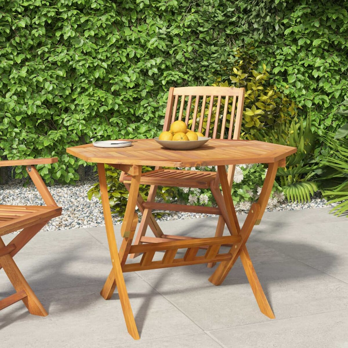 Achteckiger Holztisch mit Zitronen und Stuhl im Garten.