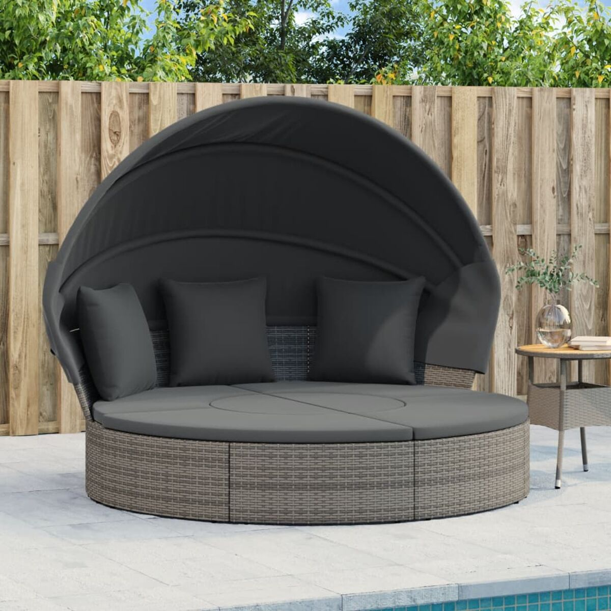 Graues rundes Rattan-Tagesbett mit Baldachin, Kissen, auf Terrasse, am Pool.