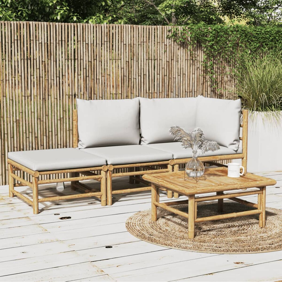 Ein Bambus-Gartenmöbel-Set mit Kissen, einem Tisch und einer Pflanze.