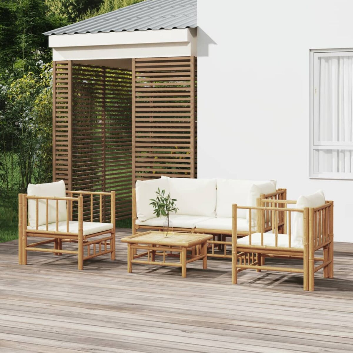 Outdoor-Bambus-Möbelset mit weißen Kissen und einem kleinen quadratischen Tisch. Holzterrasse im Hintergrund.