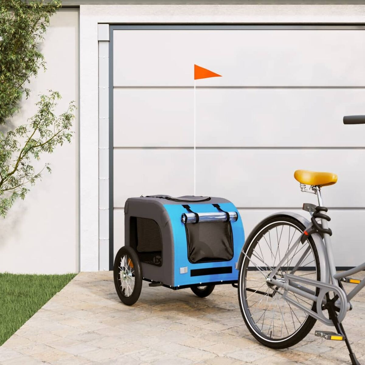 Blau-grauer Haustieranhänger an einem Fahrrad. Orange Fahne, weißes Garagentor im Hintergrund.