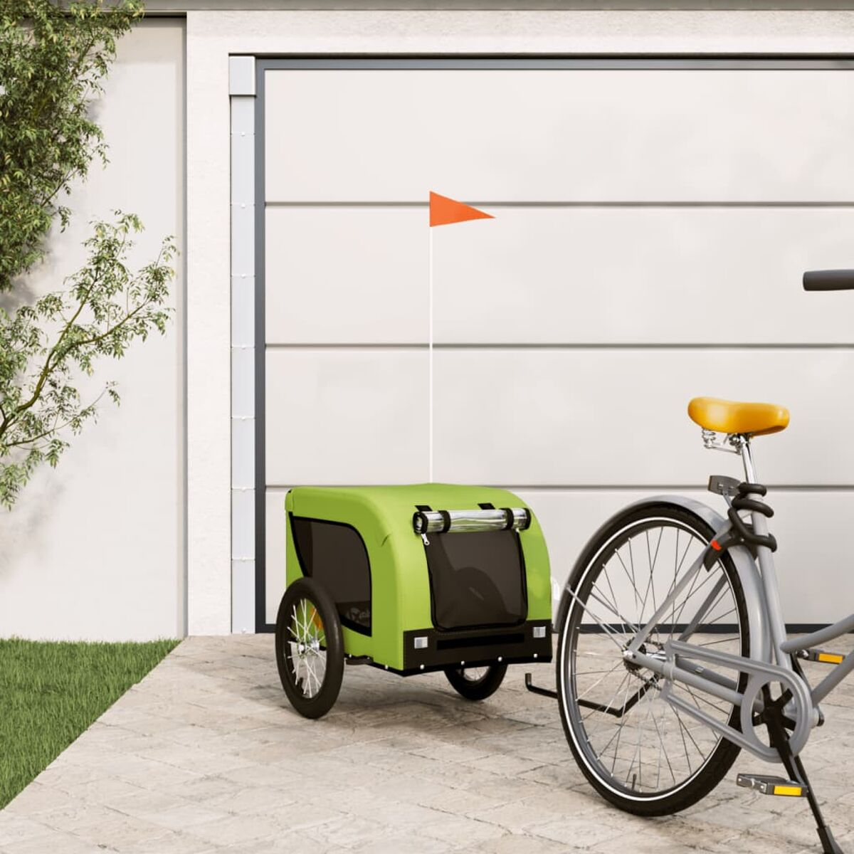 Fahrrad mit grünem Anhänger, Seitenfenster und orangefarbener Flagge. Weiße Garagentür hinten.