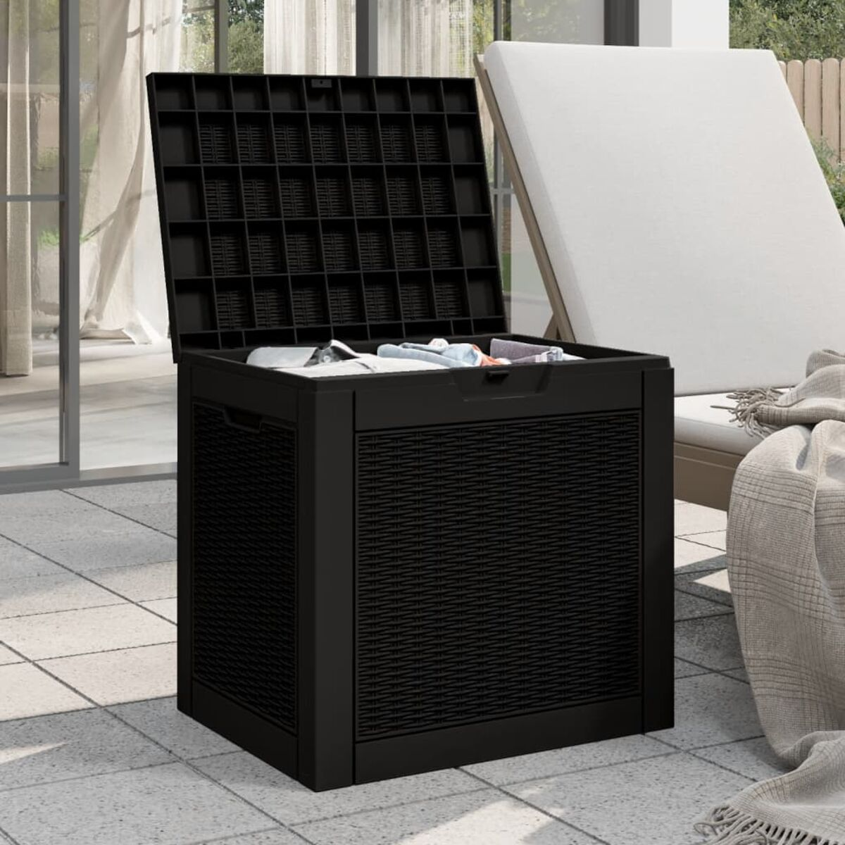Schwarze Outdoor-Aufbewahrungsbox, Deckel offen, mit Inhalt. Auf der Terrasse.
