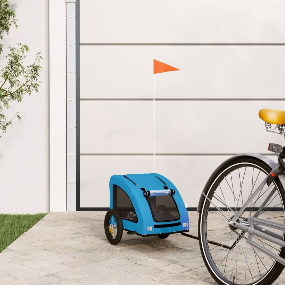Ein blauer Tieranhänger an einem Fahrrad, mit weißer Garagentür im Hintergrund.