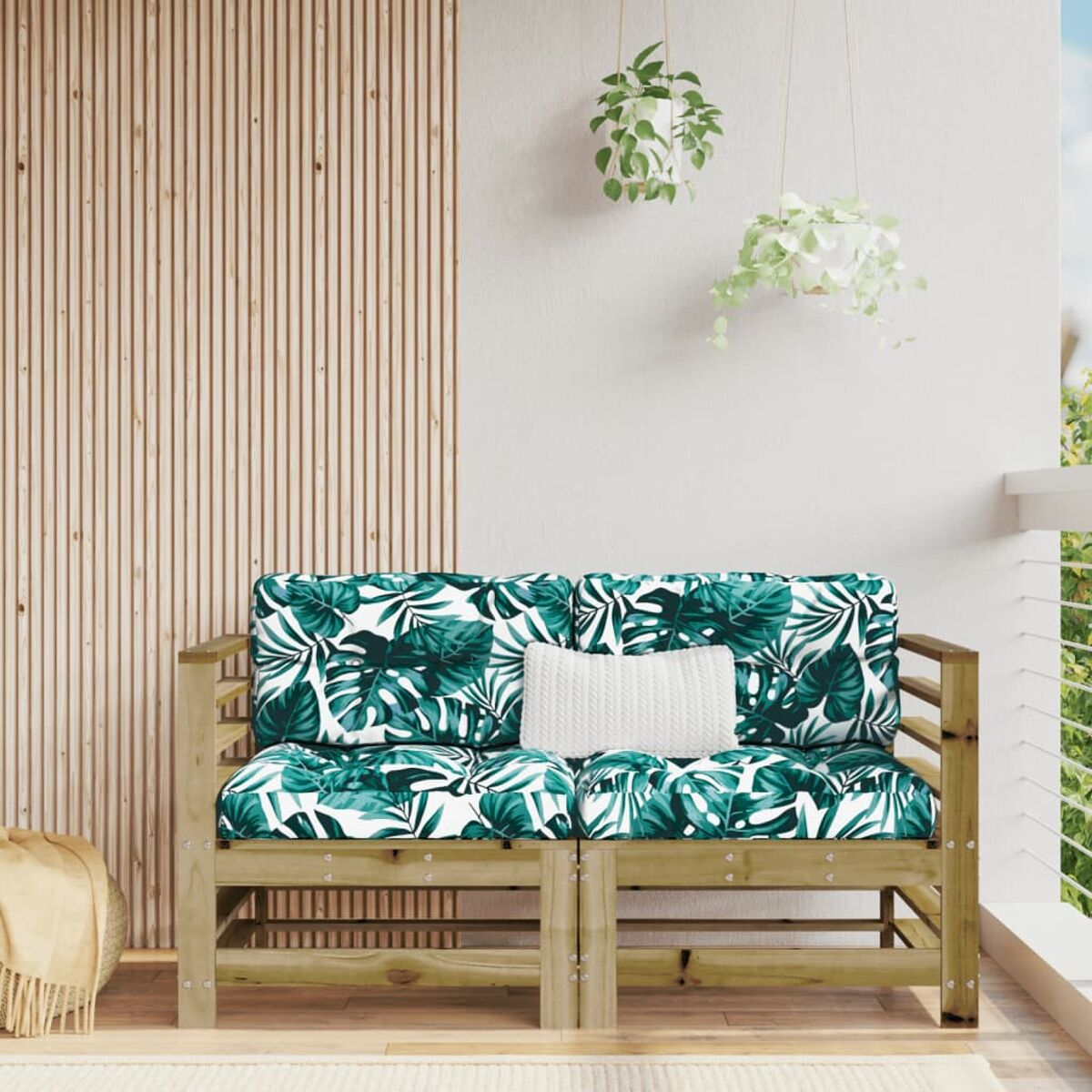 Holzsofa im Freien mit tropischen Blättermusterkissen. Holzkonstruktion mit Teppich.