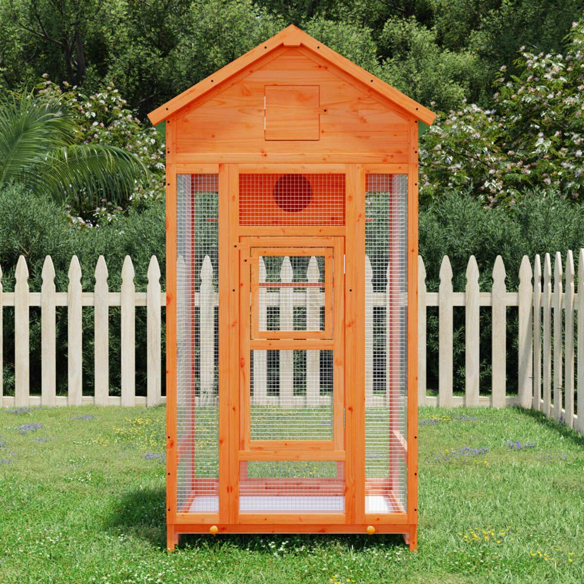 Vogelhaus im Freien, orange mit Drahtgitterseiten und weißem Zaun im Hintergrund.