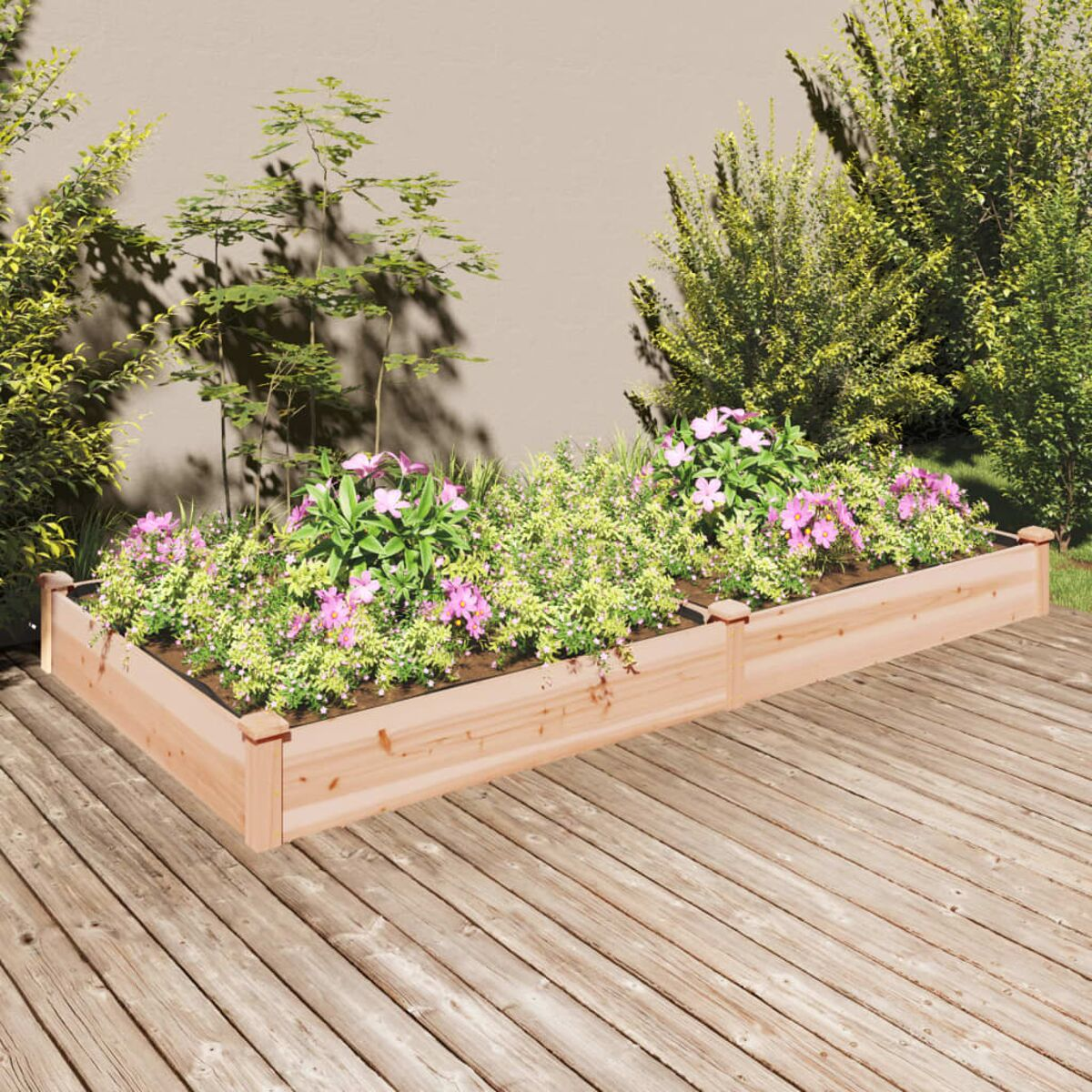 Erhöhtes Beet mit Blumen. Hellbraunes Holz, grüne Pflanzen und rosa Blüten.