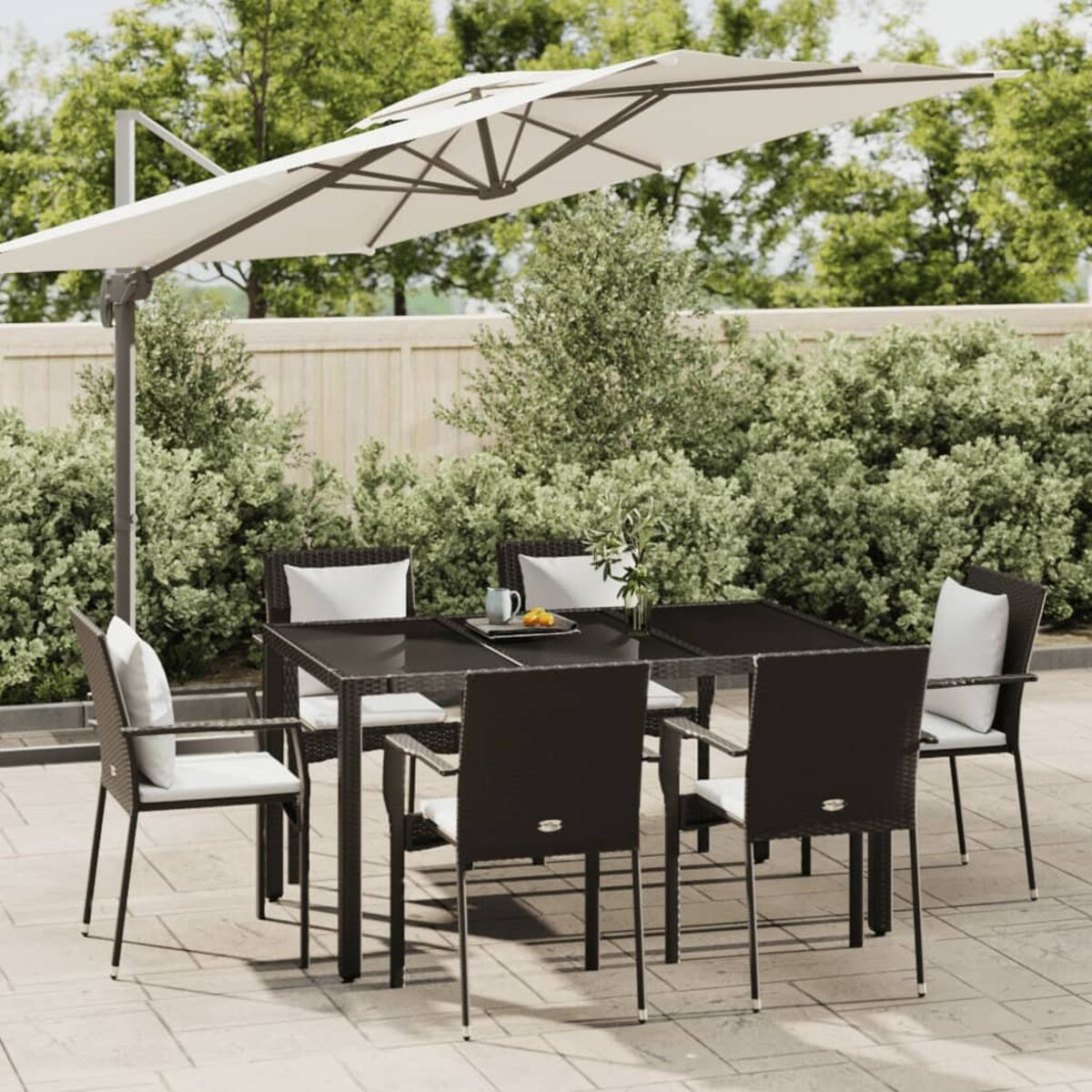 Essgruppe für draußen mit Tisch und sechs Stühlen. Enthält einen großen weißen Schirm. Auf Terrasse.