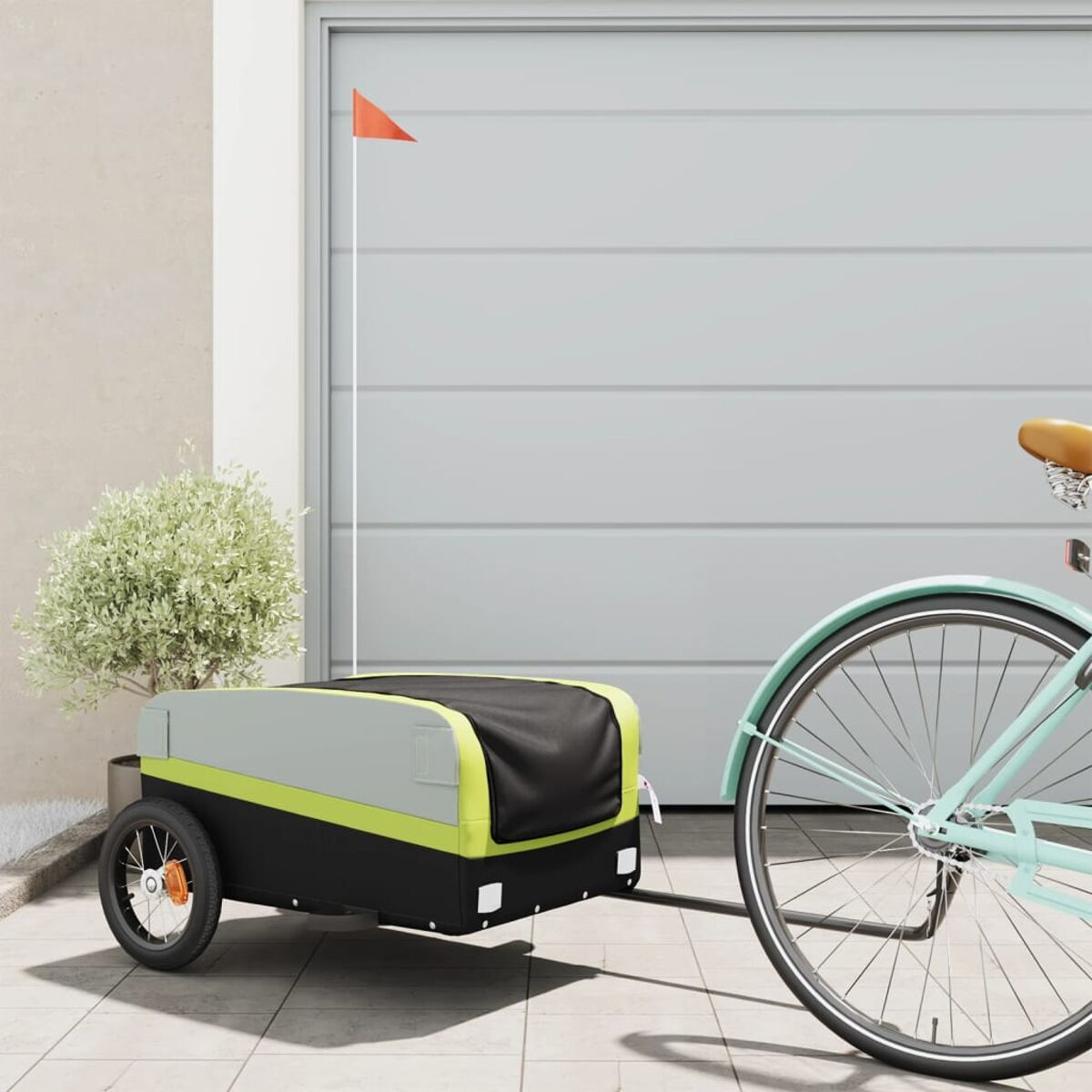 Fahrrad mit Anhänger. Anhänger ist schwarz, grün und grau mit einer orangefarbenen Fahne.
