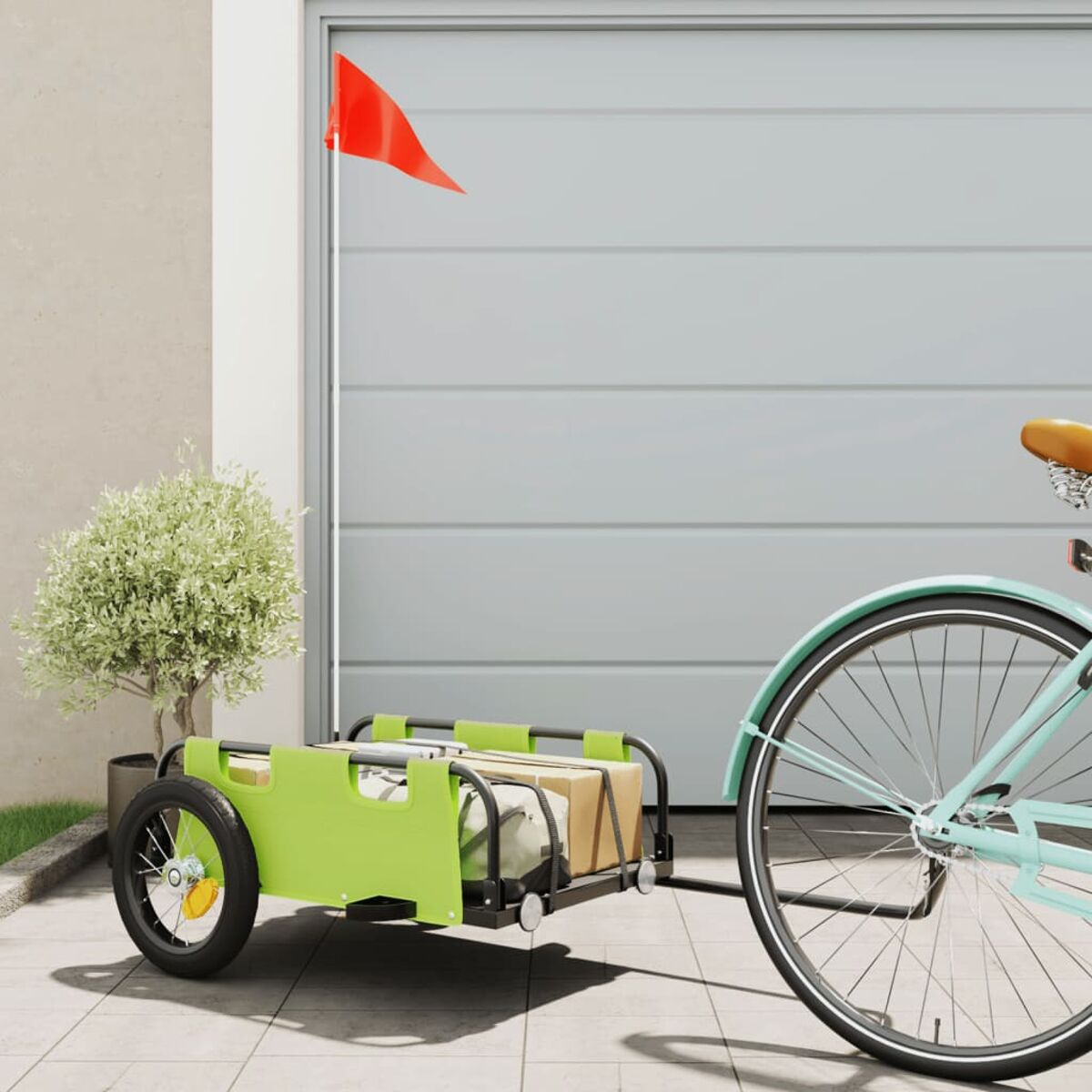 Ein grüner Anhänger an einem Fahrrad mit roter Fahne.