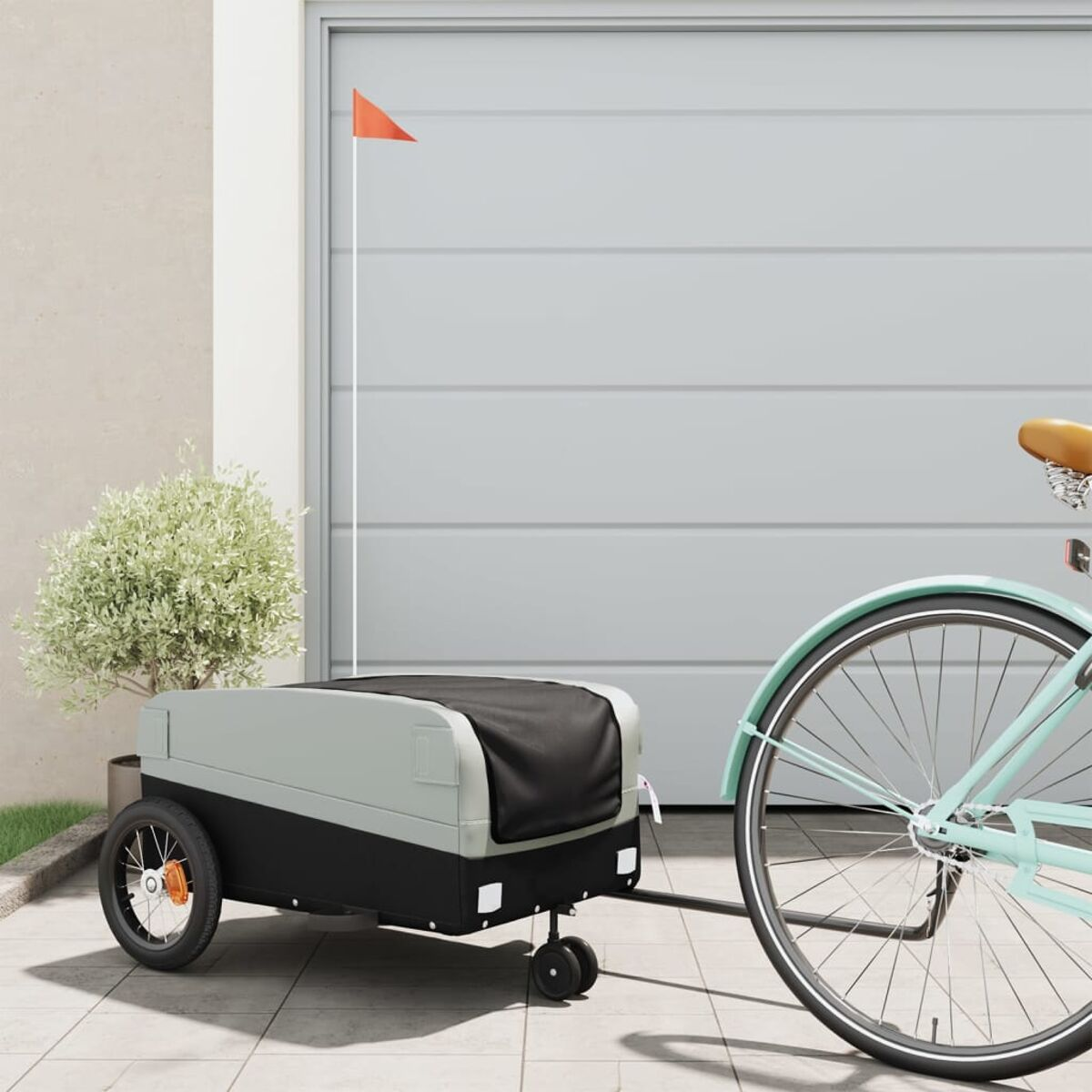 Ein Fahrrad, das einen Anhänger mit einer Flagge neben einer Garage zieht.