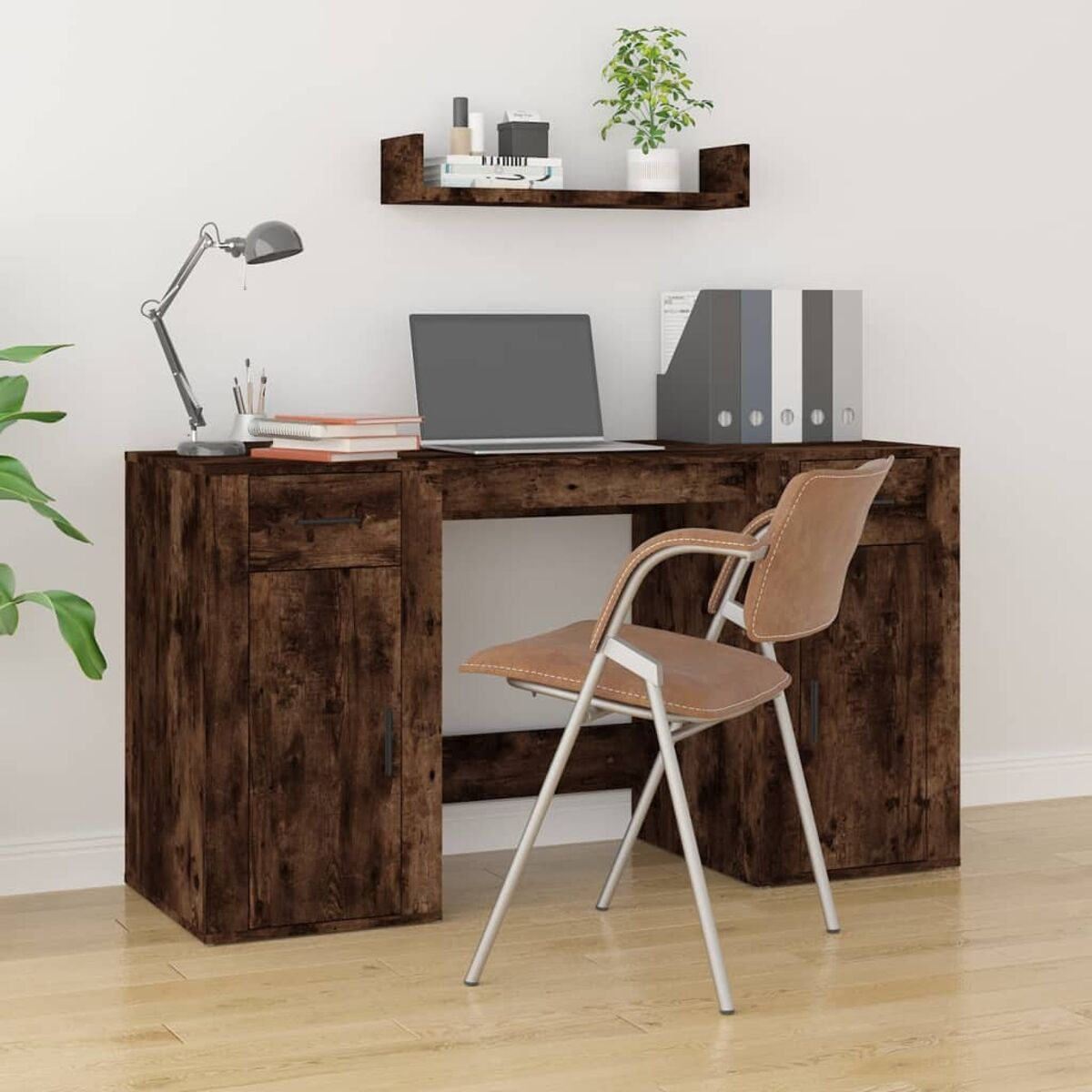 Dunkelbrauner Holzschreibtisch mit Laptop, Lampe und Stuhl. Darüber ein Regal mit Gegenständen.