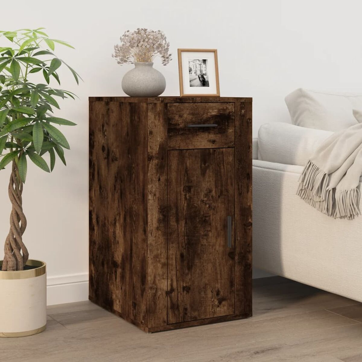 Ein Holzschrank mit Schublade und Tür. Eine Vase und ein gerahmtes Foto stehen oben drauf.