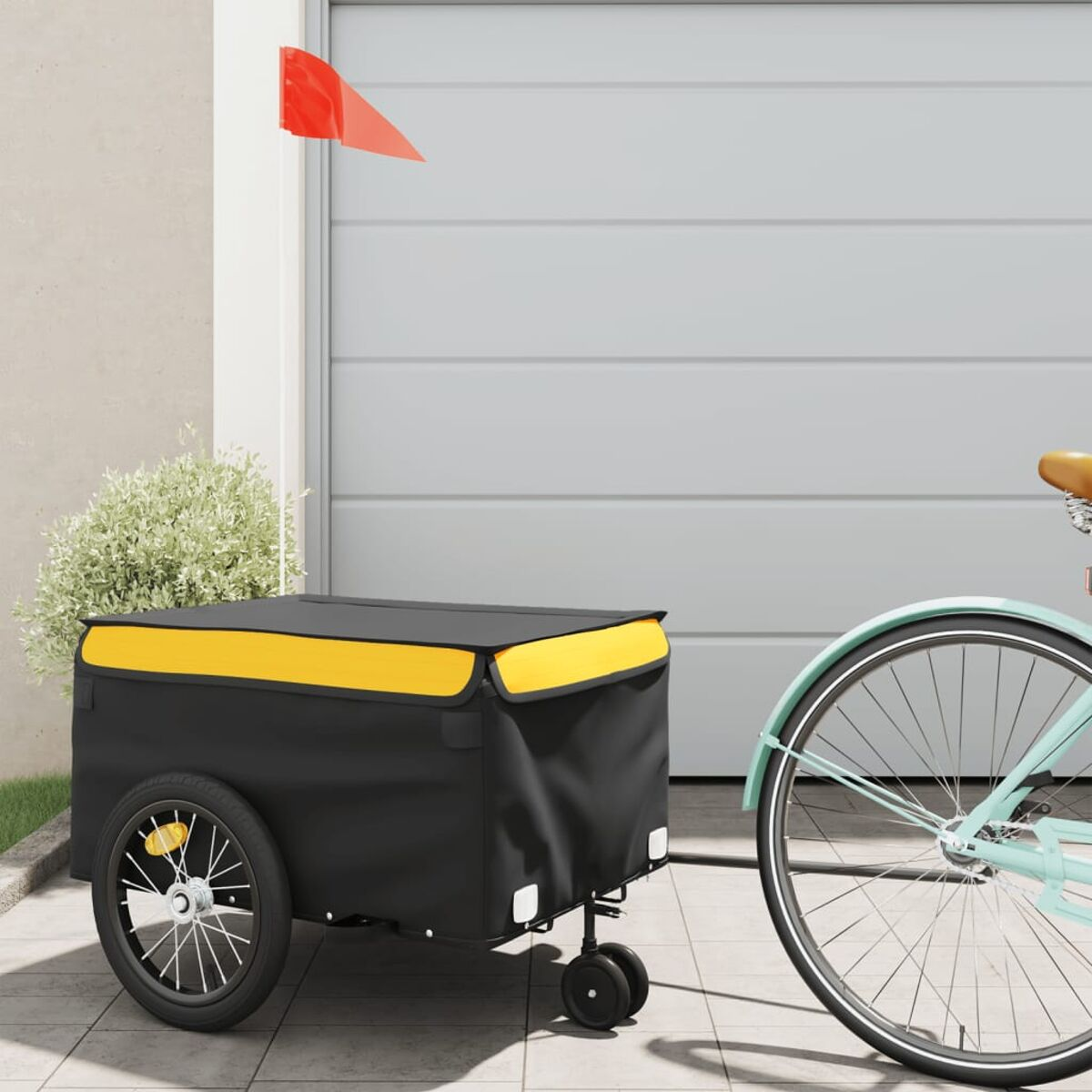 Ein Fahrrad mit Anhänger. Der Anhänger ist schwarz und gelb, am Fahrrad befestigt. Eine rote Fahne ist am Anhänger befestigt.