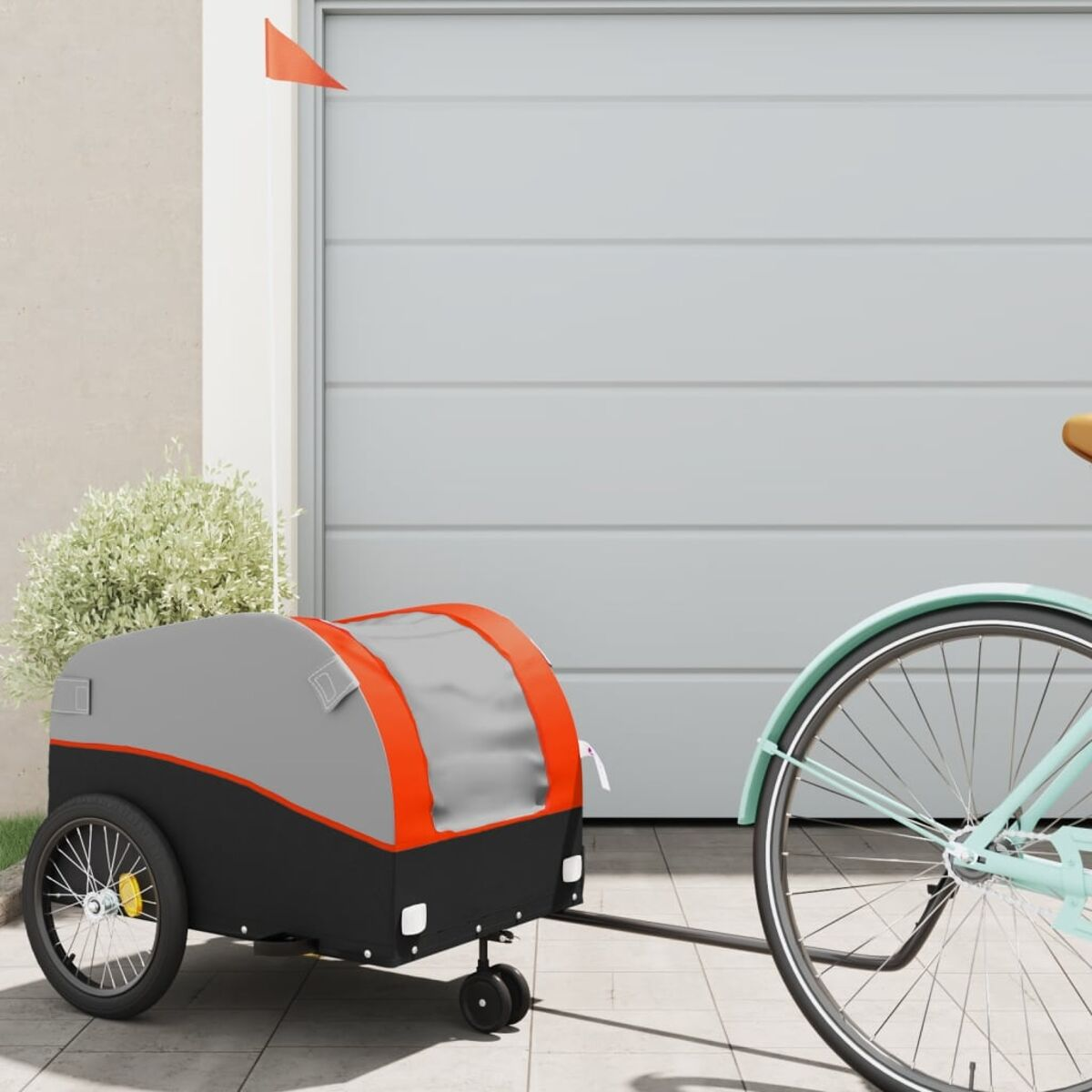 Ein Fahrrad zieht einen grau-orangenen Anhänger. Am Anhänger ist eine Fahne befestigt.